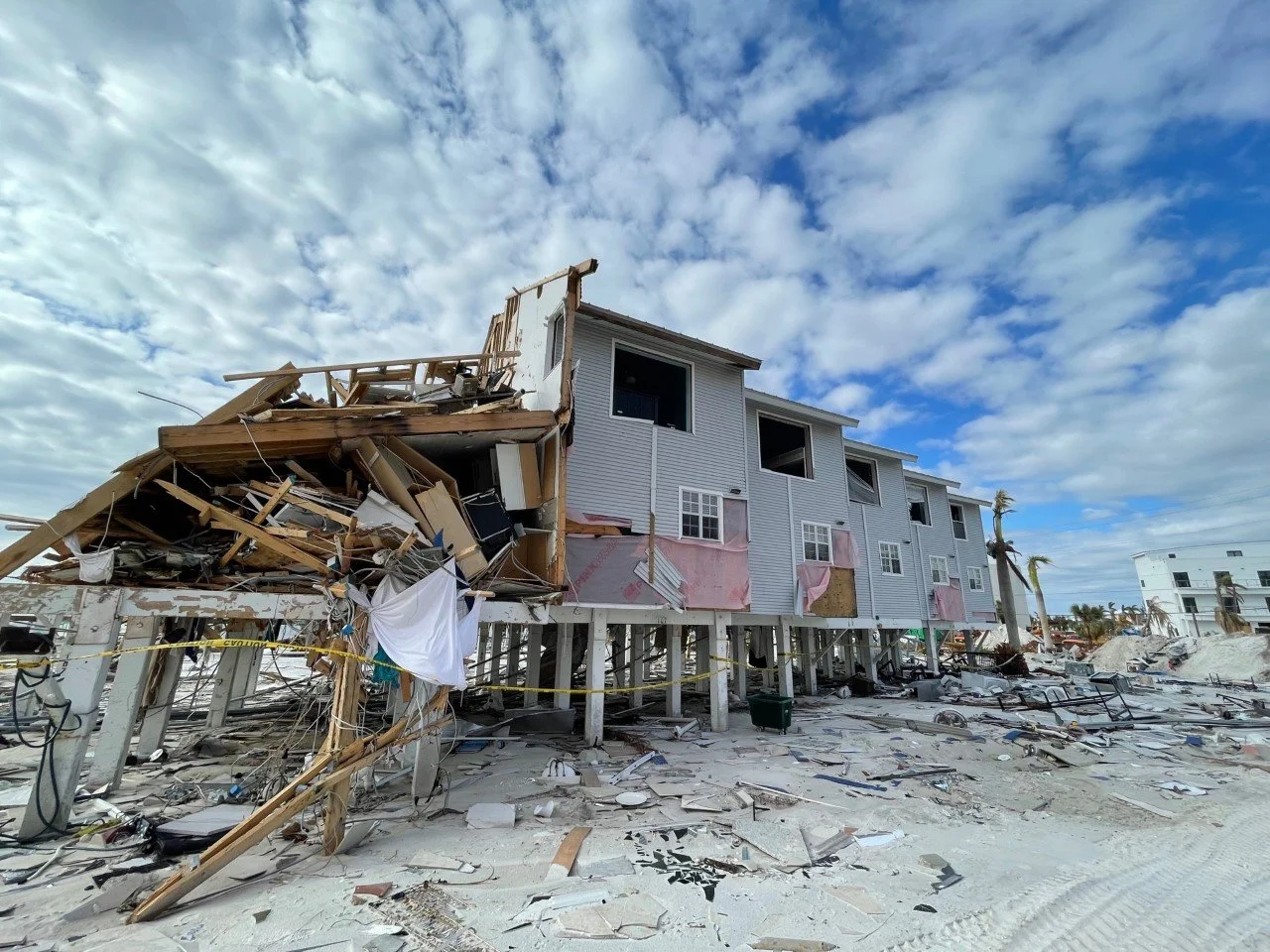 A house ruined by Hurricane Ian. Crumbled siding wood on the ground.