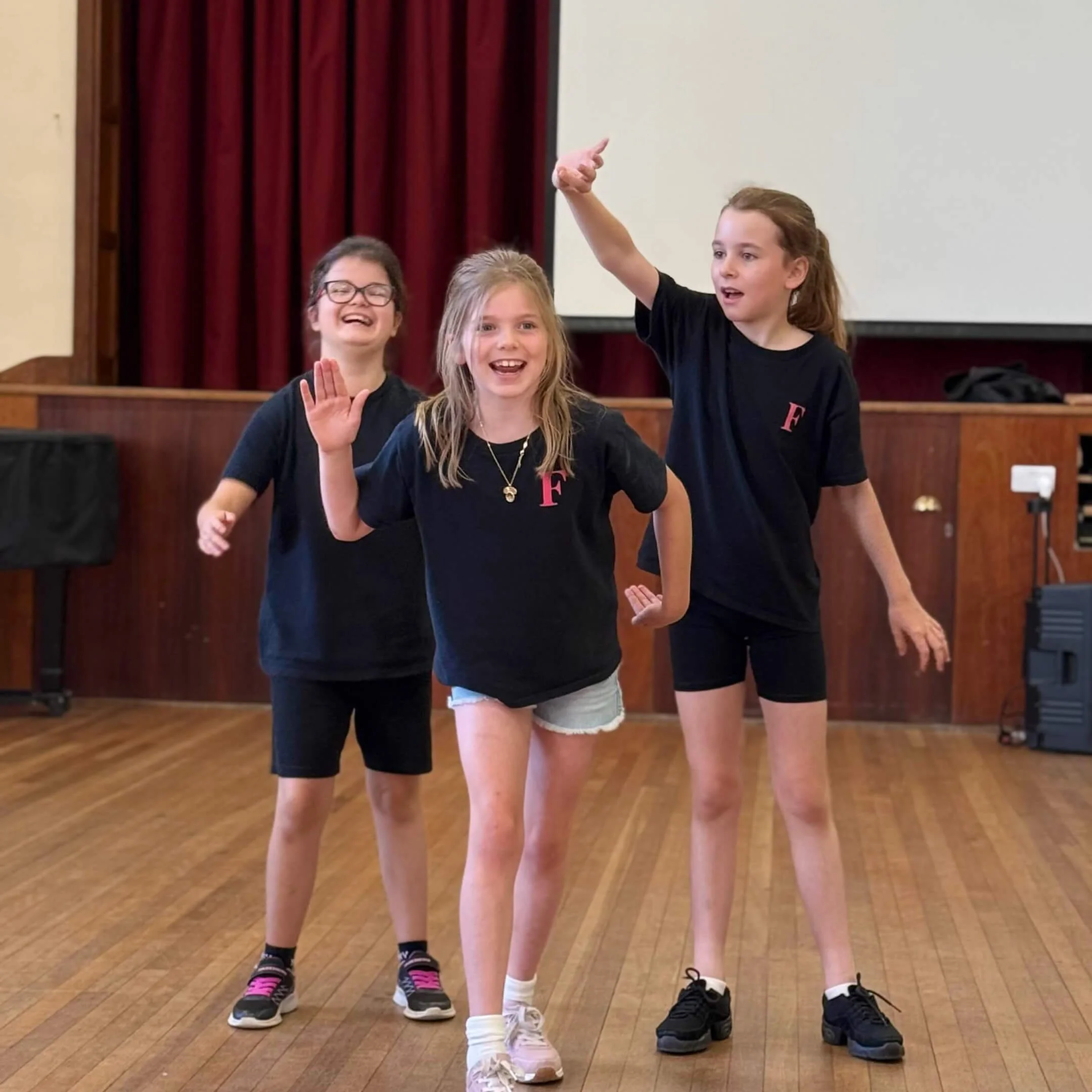 Children aged 6 to 16 acting out a scene in a drama class