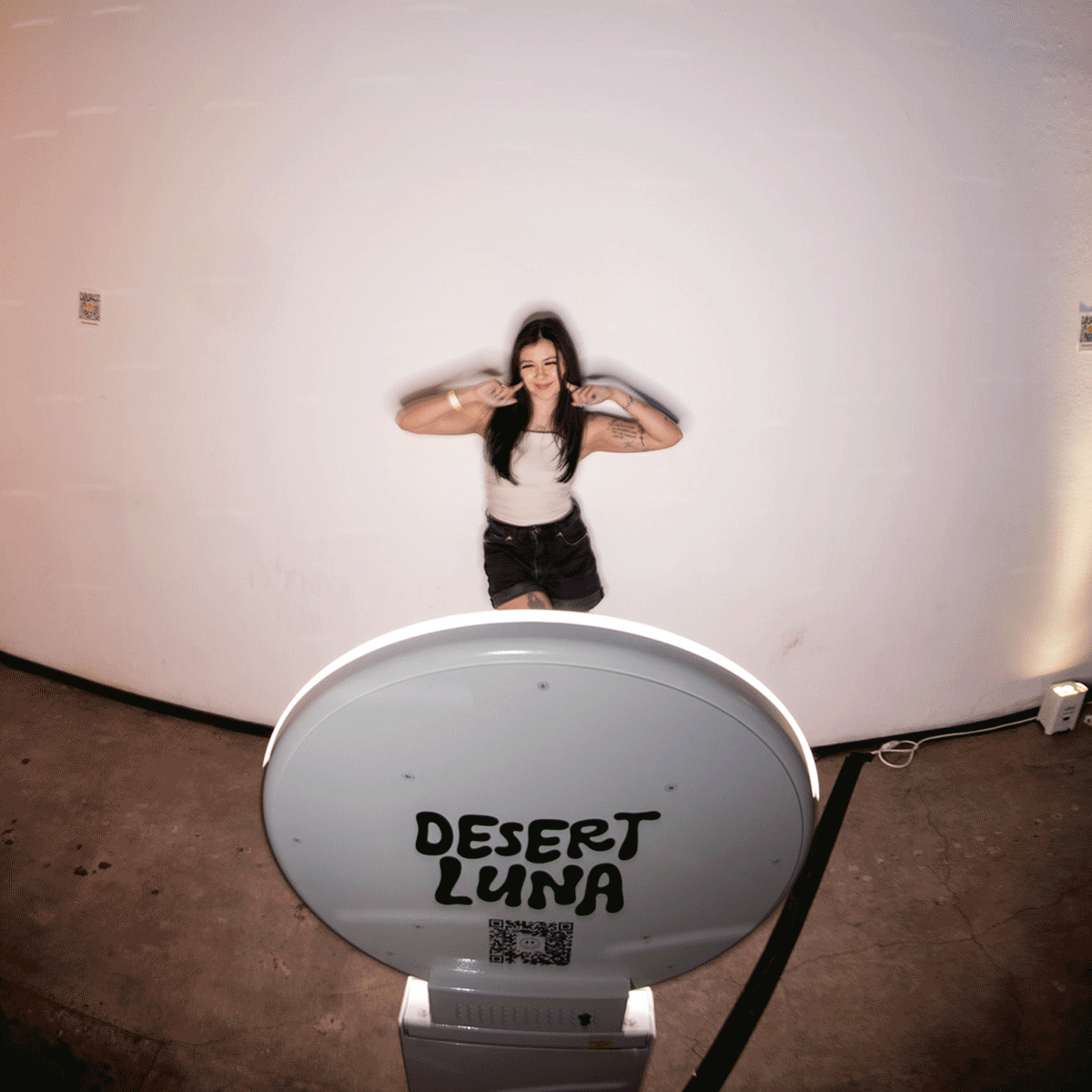 girl posing in front of digital photo booth with custom tap to start screen and branded templates