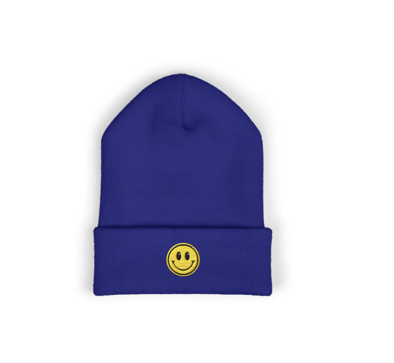 Blue knit beanie hat with a yellow smiley face patch on the front
