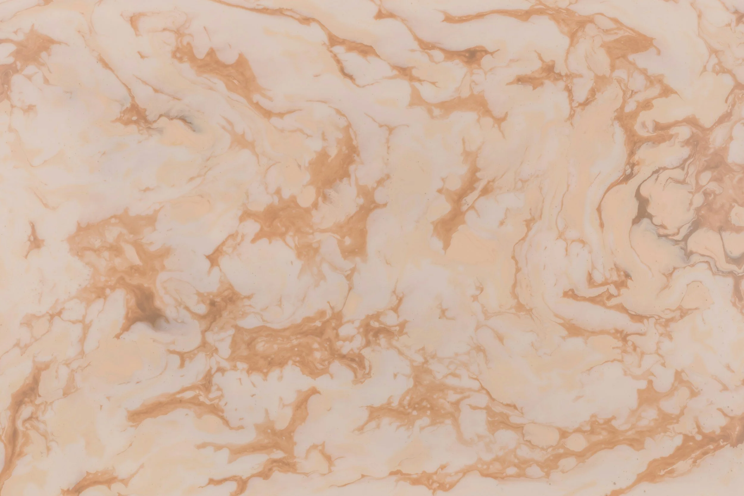 Marble surface with a peach and beige veined pattern.