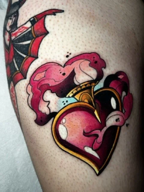 Tattoo of a broken heart with bright colors and artistic details.