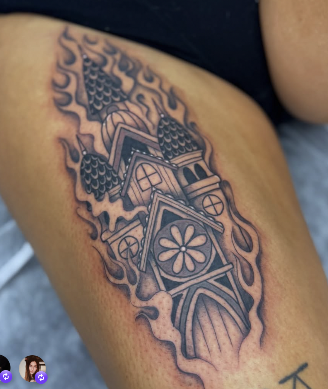 A traditional-style house tattoo on an arm, featuring decorative elements such as flowers and flames.