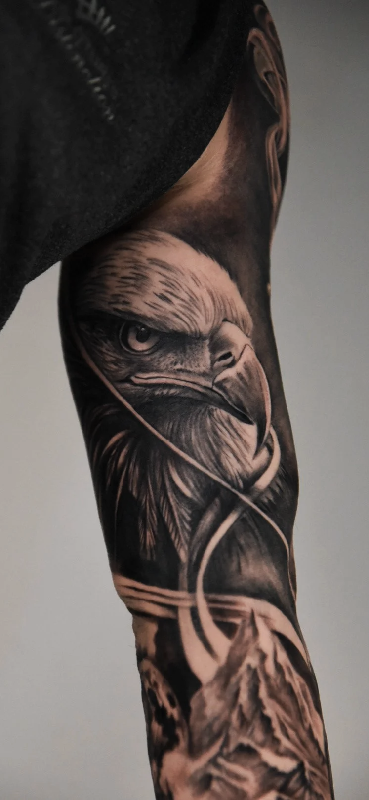 Realistic tattoo of a front eagle on the arm.
