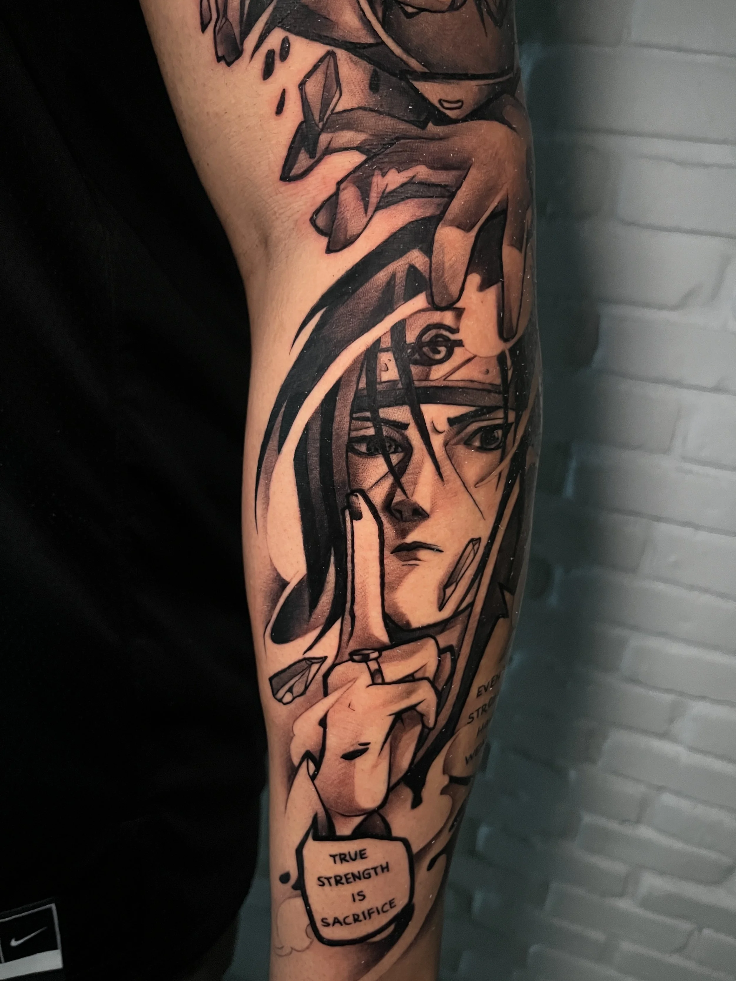 Black and gray tattoo depicting a female character with one hand in front of her face, wearing a headband with the leaf symbol, with a dialog box saying 'True strength is sacrifice'.