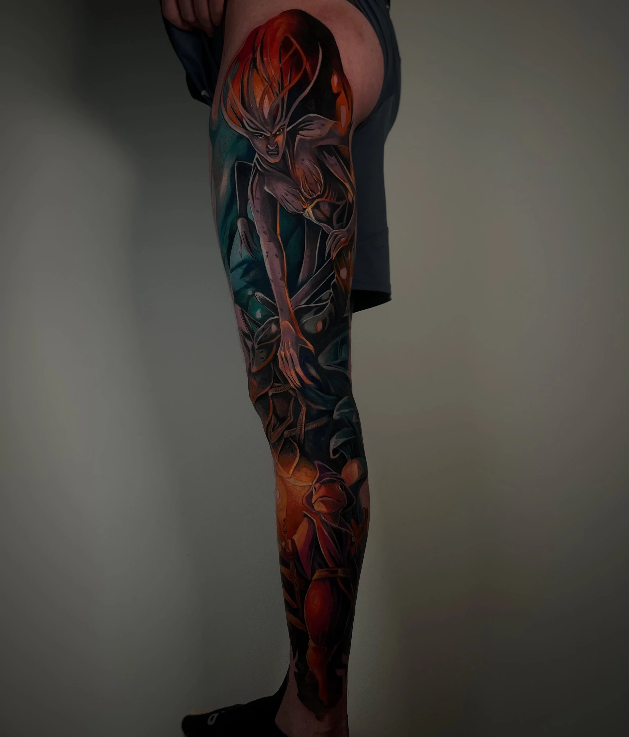 A tattoo of a woman leaning over the ground, with long hair and an angry expression.