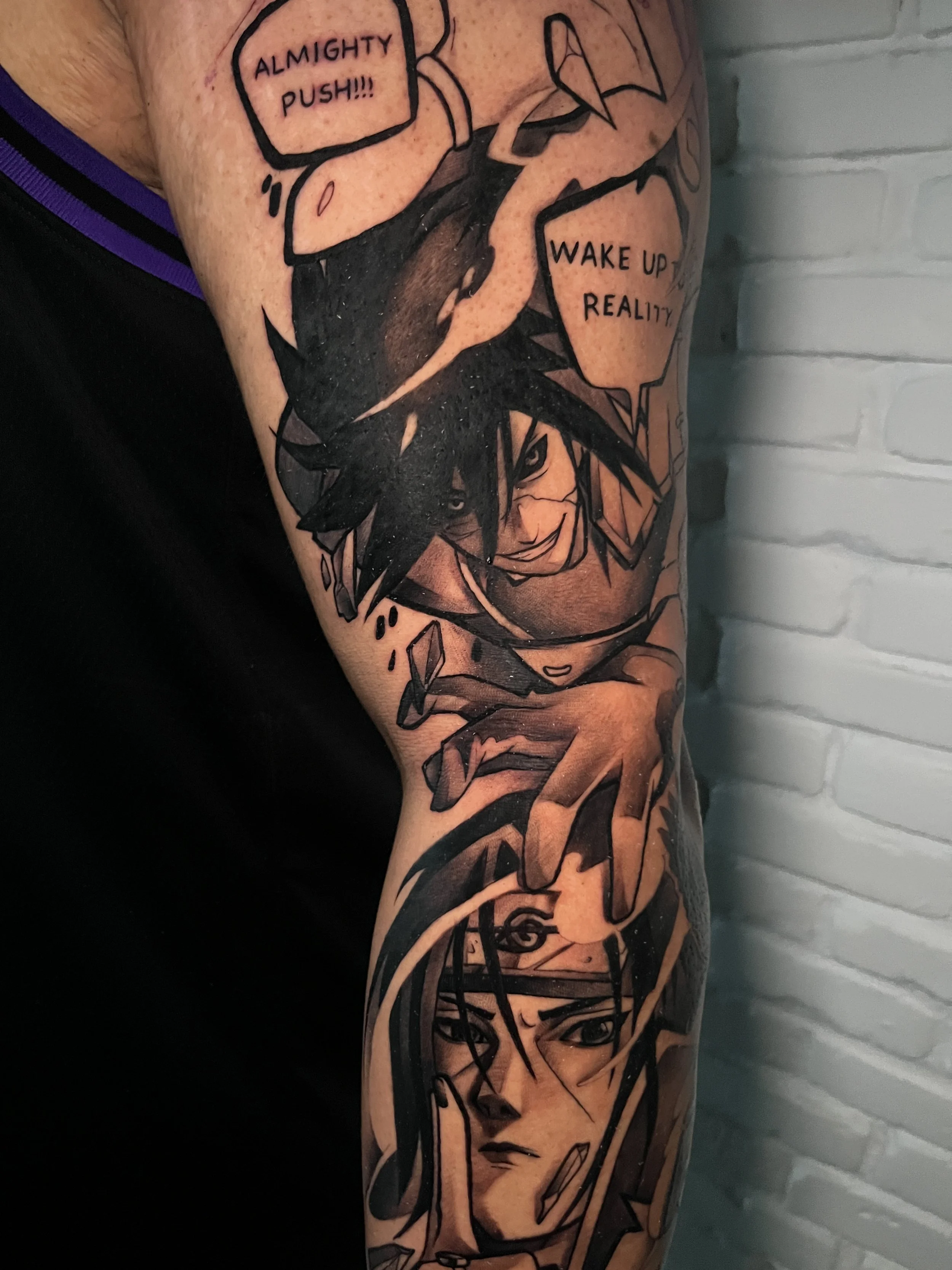 Tattoo of two manga characters, with speech bubbles in English saying 'Almighty push!!!' and 'Wake up to reality'.