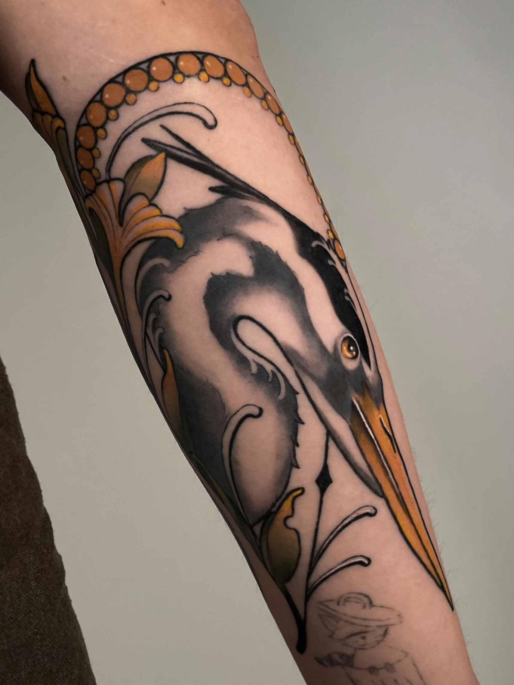 Tattoo of a fish, probably a piranha, on the arm with black, gray and orange details.