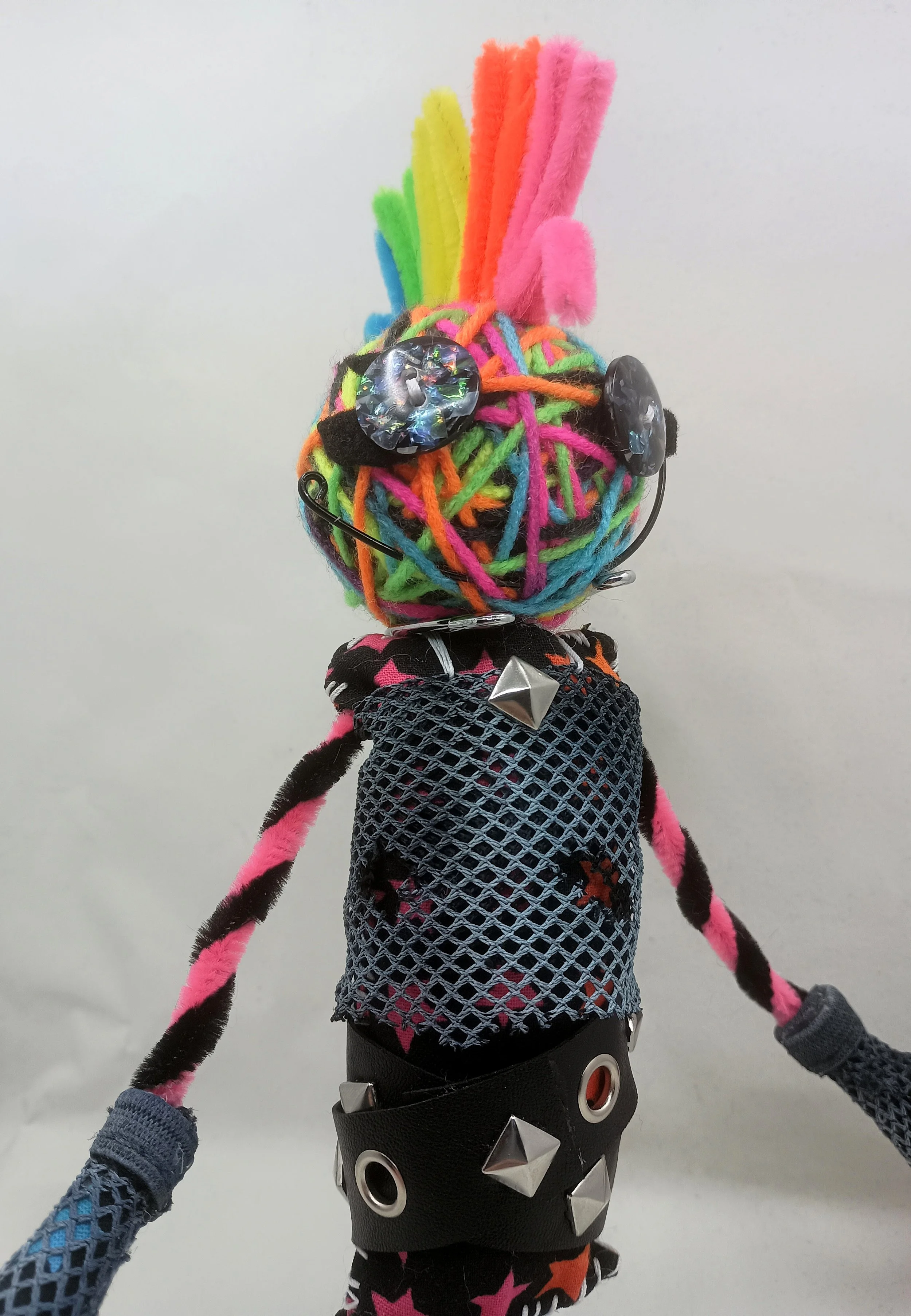 Glamrock Omni Doll Detail, yarn, pipe cleaners, buttons, mesh, faux leather ribbon, 2025
