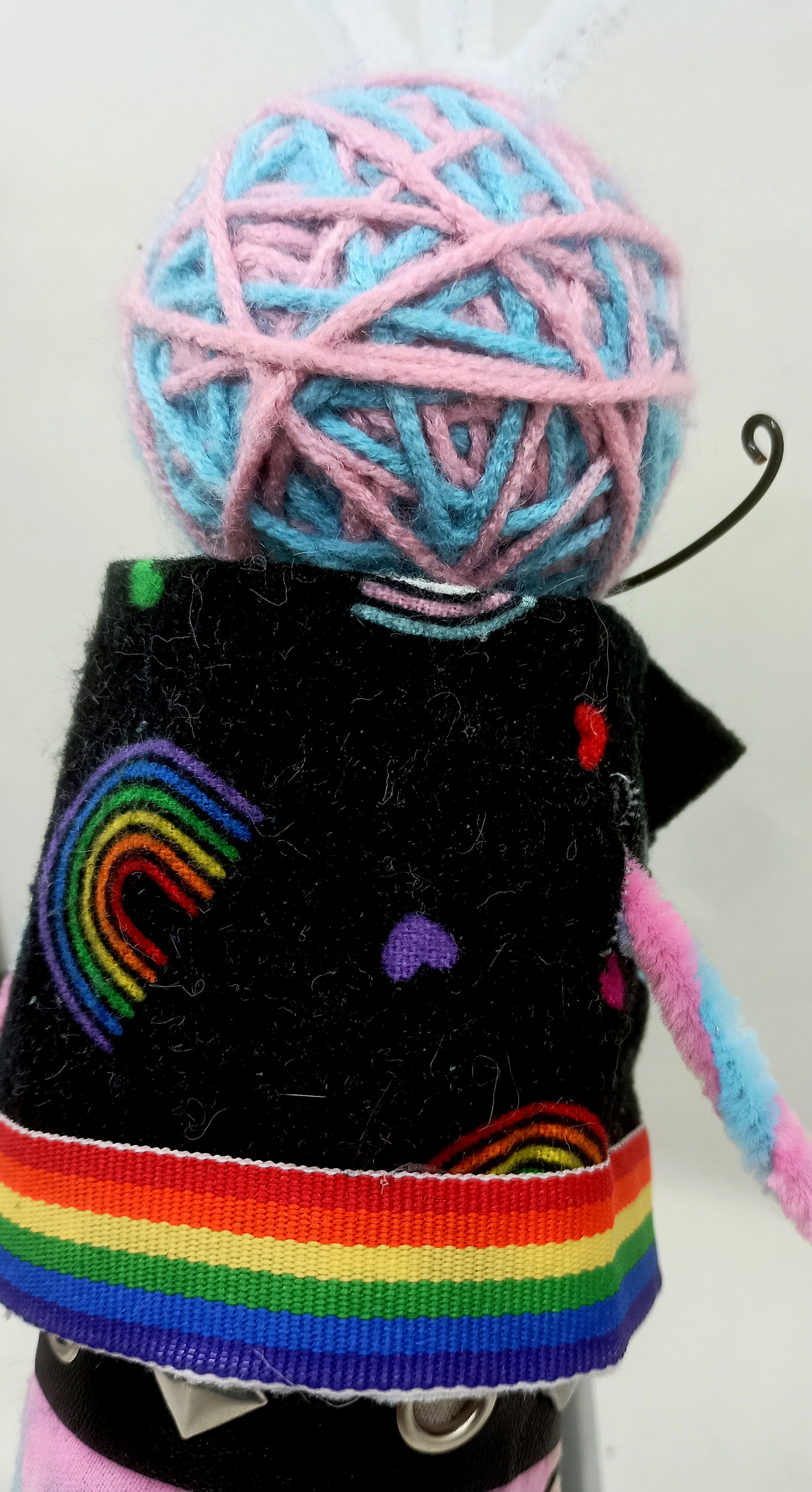 Trans Punk Omni Doll Detail, yarn, buttons, pipe cleaners, acrylic paint, faux leather ribbon, 2025