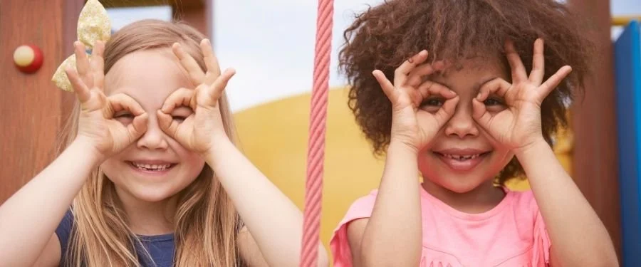 Kaksi lasta kädet silmien ympärillä