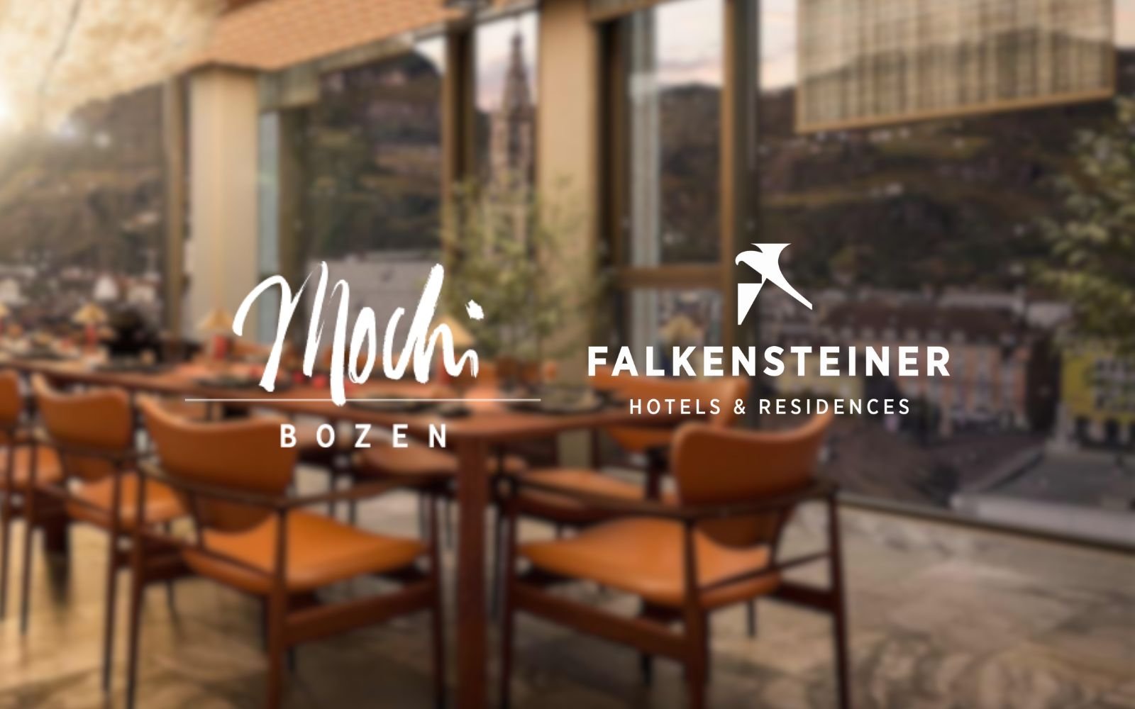 Interior view of a restaurant or hotel dining area with large windows and wooden furniture, overlaid with logos and text for Mochi Bozen and Falkensteiner Hotels & Residences.