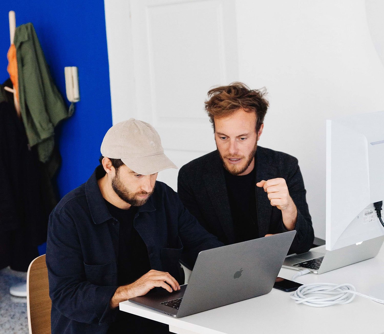 L'immagine mostra i membri del team che collaborano, entrambi guardando un computer, all'interno dell'ufficio.