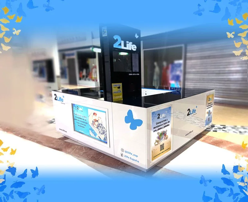 Puente de información de la compañía 2Life en un centro comercial, con pantallas y anuncios publicitarios.