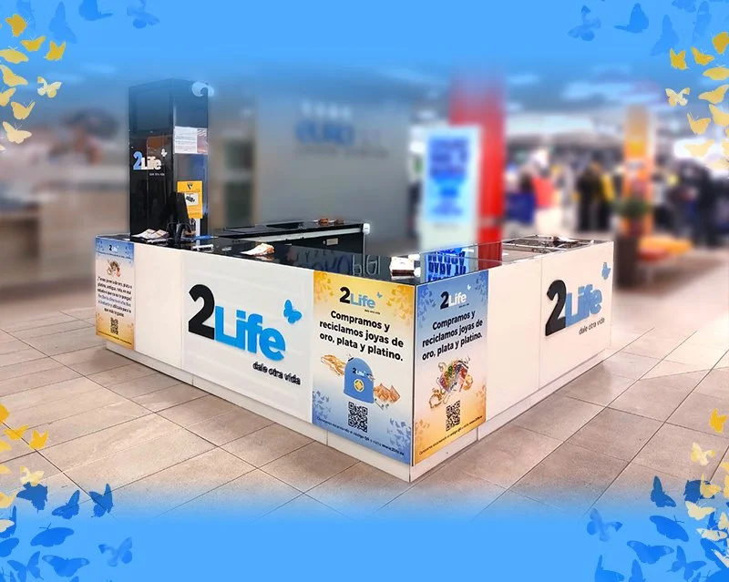 Estación de recolección de metales y joyas en un lugar público, con un cartel que dice '2Life'.