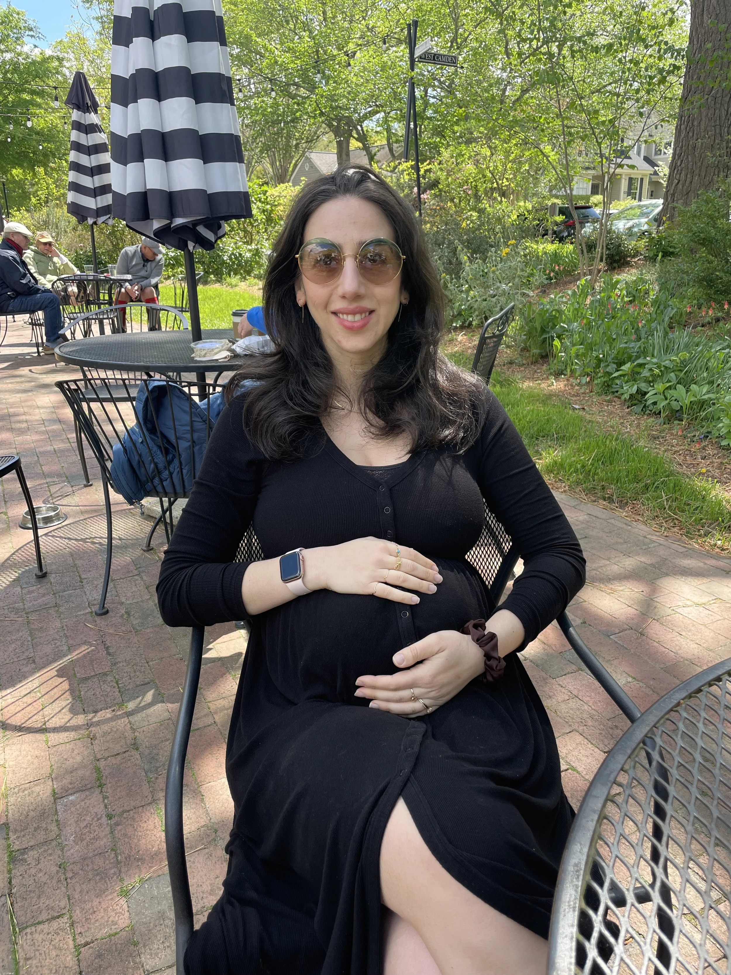 Mayya, heavily pregnant, with black dress, sunglasses.