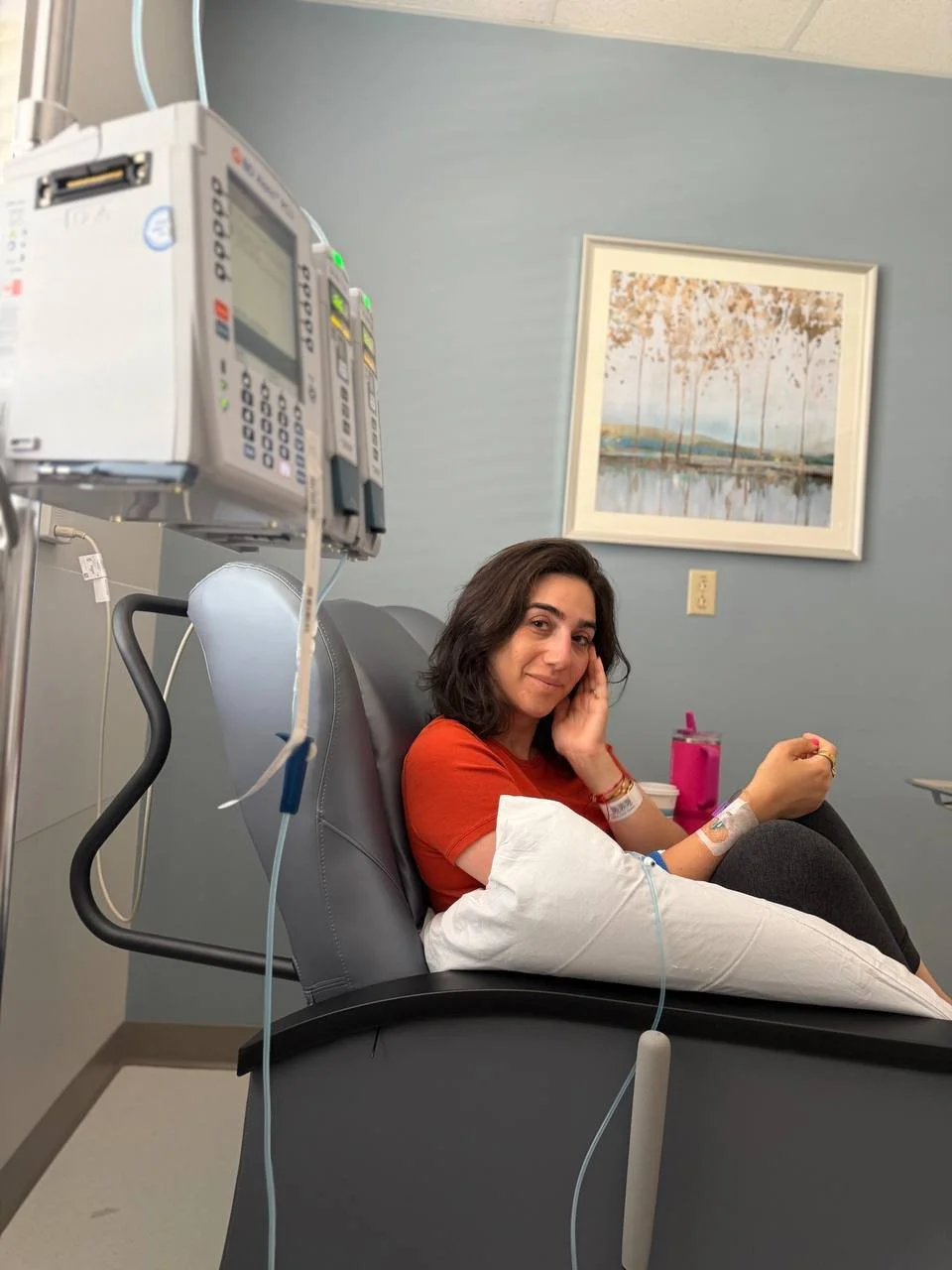 A smiling Mayya, on a reclining chair receiving chemotherapy. Despite this she's smiling and feeling great.