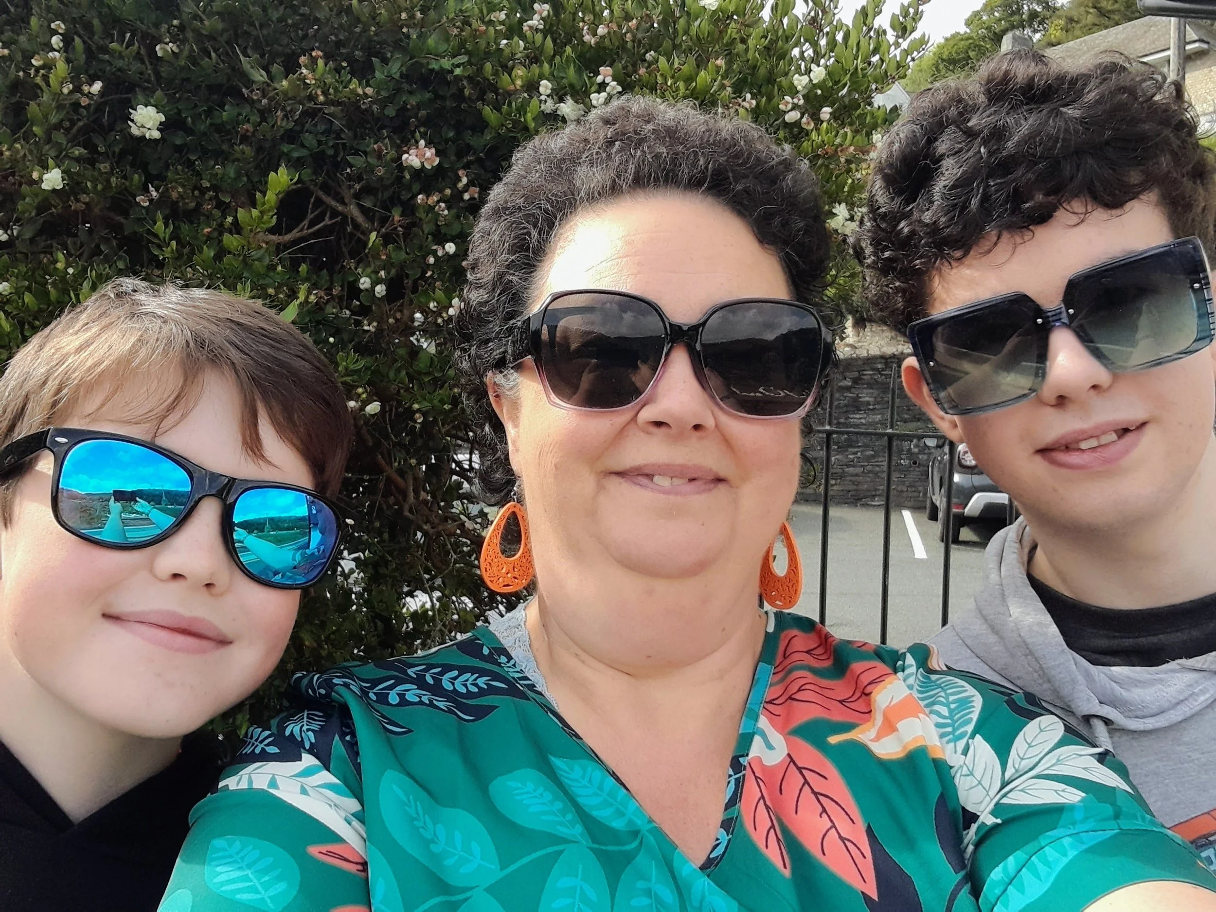 Photo of Allison with her two sons, smiling in the sunshine.