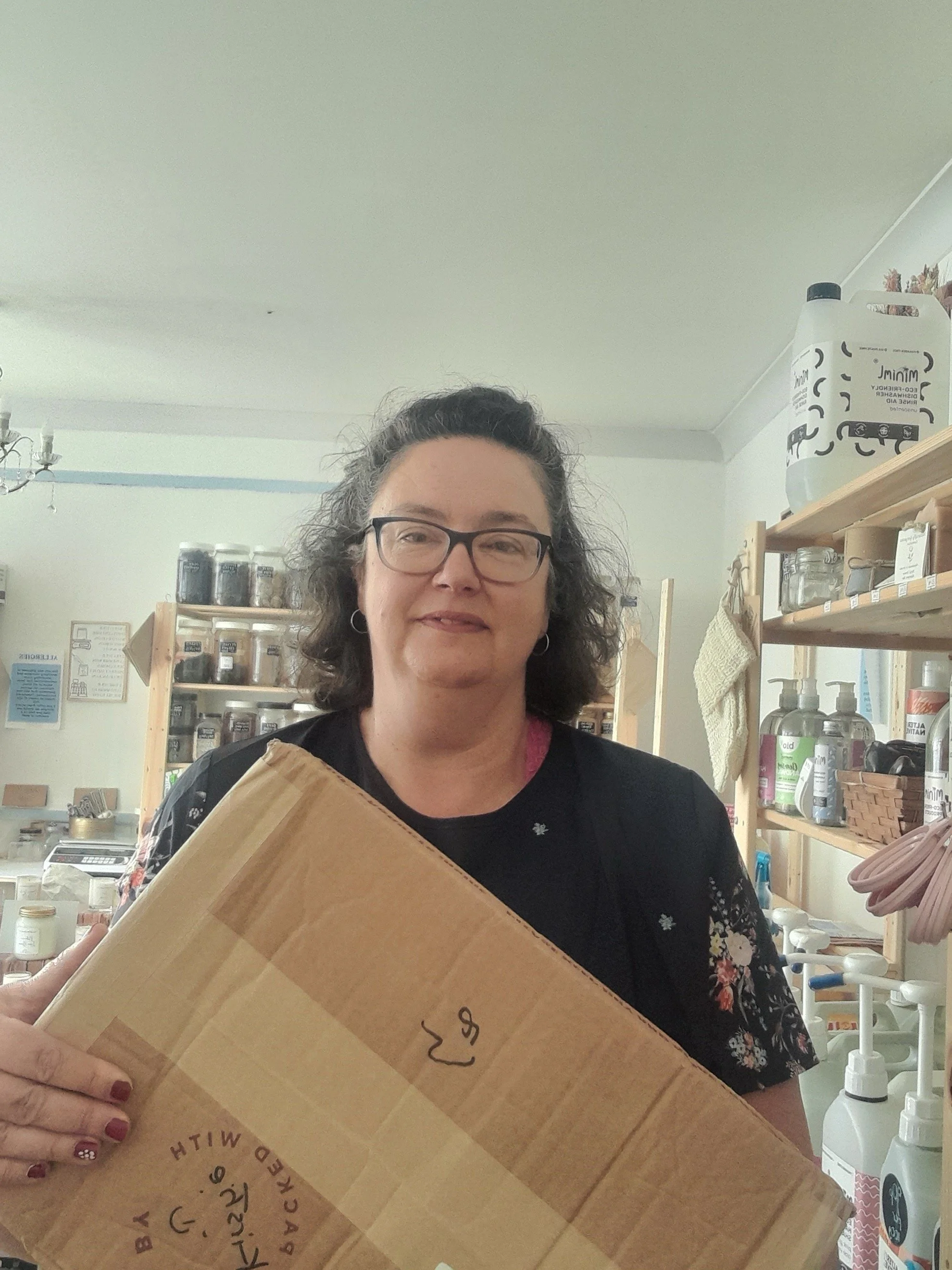 Allison, holding a box in her shop store room.  Taken two days after her breast cancer diagnosis.