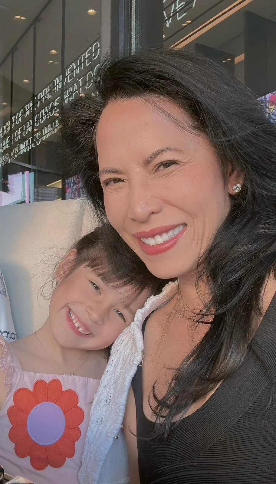 Kimberly and her daughter leaning on her shoulder and smiling.