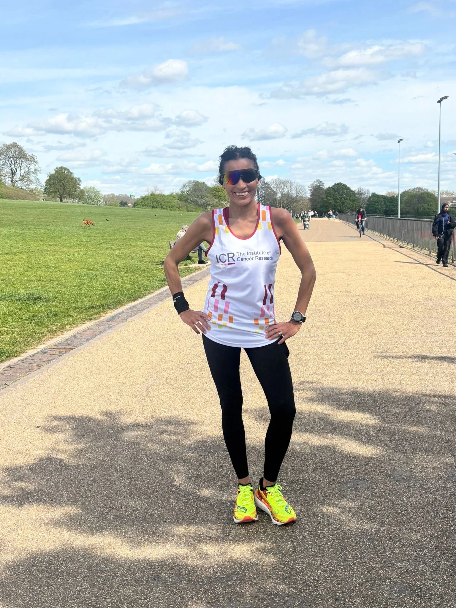 Photo of OCR supporter Mandy Tafler in her London Marathon ICR running shirt.  Supporting fundraising for lung cancer research. Mandy is in running legging, with big sunglasses and a big smile in a field in London