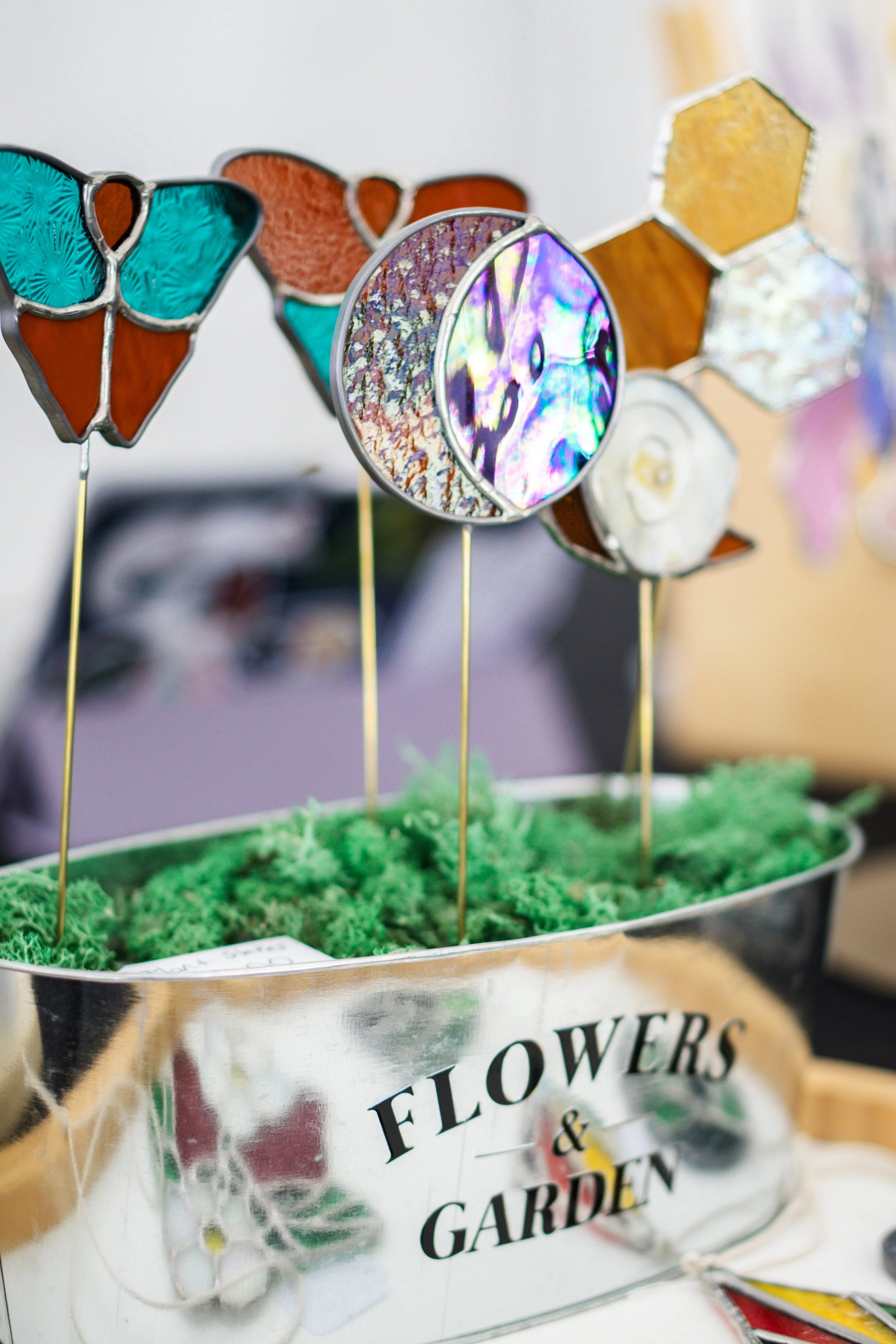 Handmade stained-glass garden stakes in butterfly, moon, and honeycomb shapes
