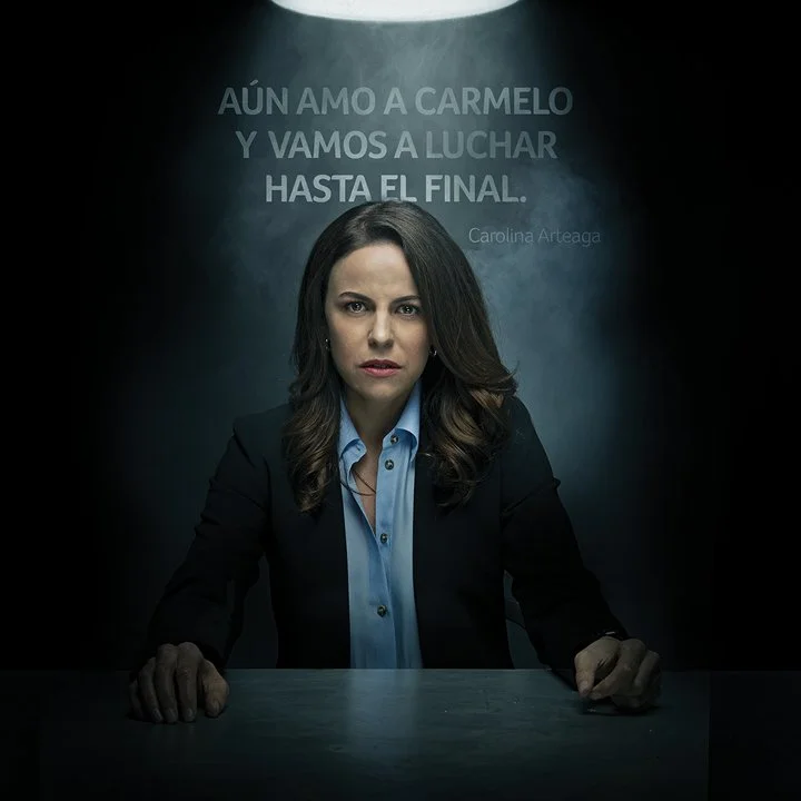 A serious woman sitting at a table with a dark background. There is a quote in Spanish on the wall behind her reading 'AÚN AMO A CAMELLO Y VAMOS A LUCHAR HASTA EL FINAL.' and her name, Carolina Arteaga, appears below.