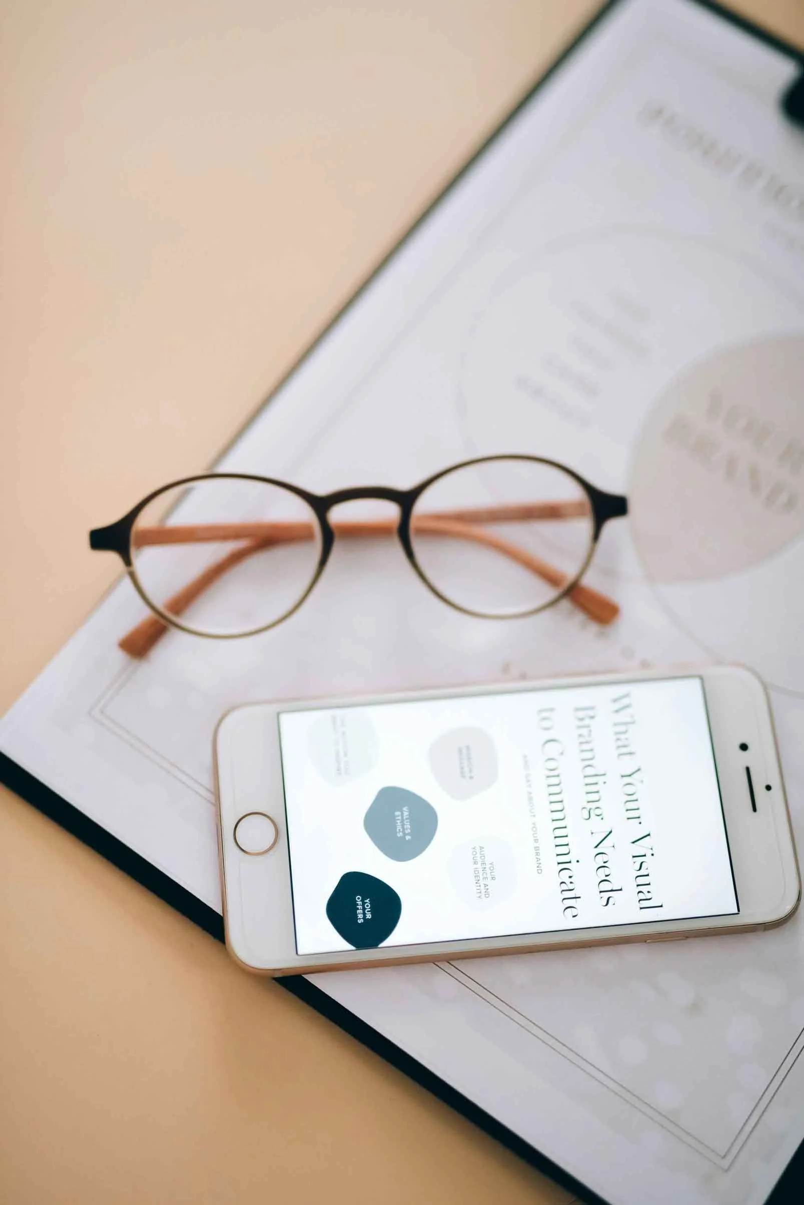 Glasses and phone resting on a nonprofit key messages and branding workbook