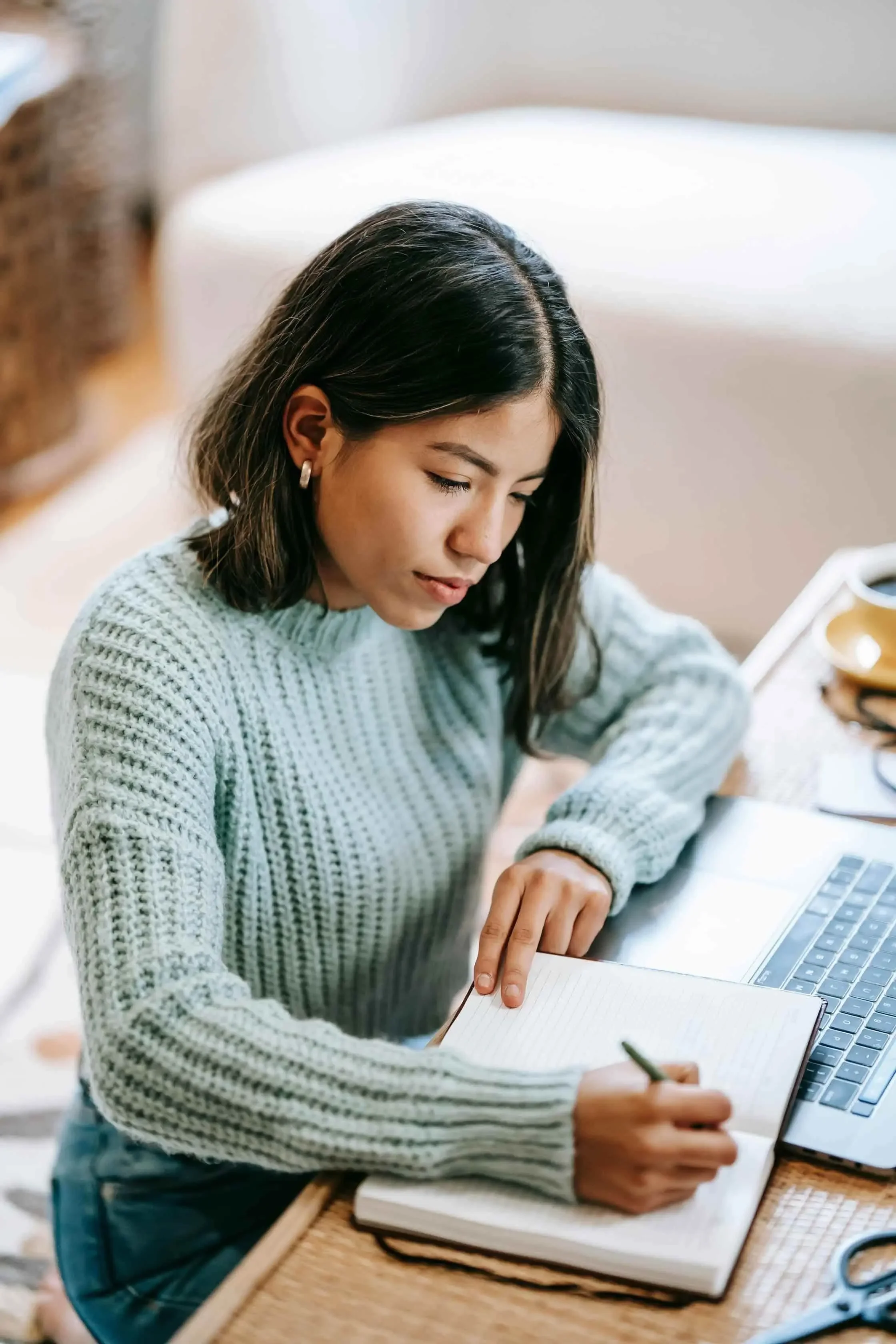 Nonprofit leader writing her nonprofit marketing plan with laptop
