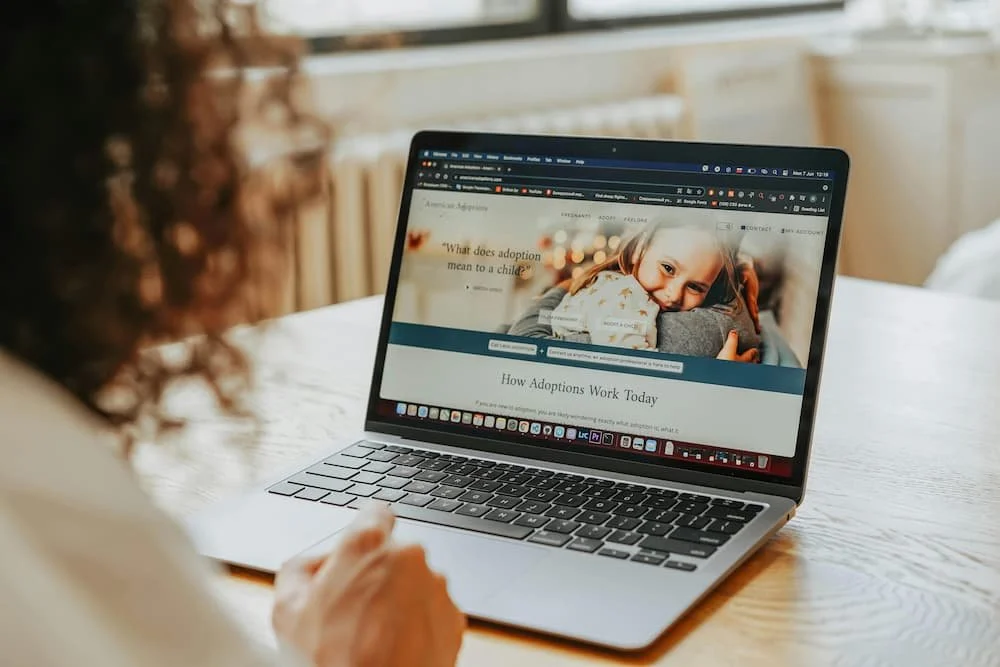A woman reviewing a nonprofit website strategy on a laptop at a desk