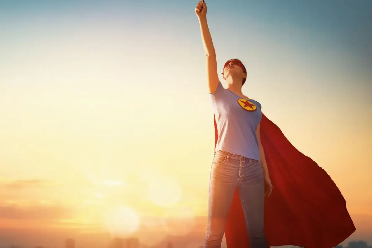 Person in superhero cape at sunset representing the donor as hero in nonprofit donor engagement