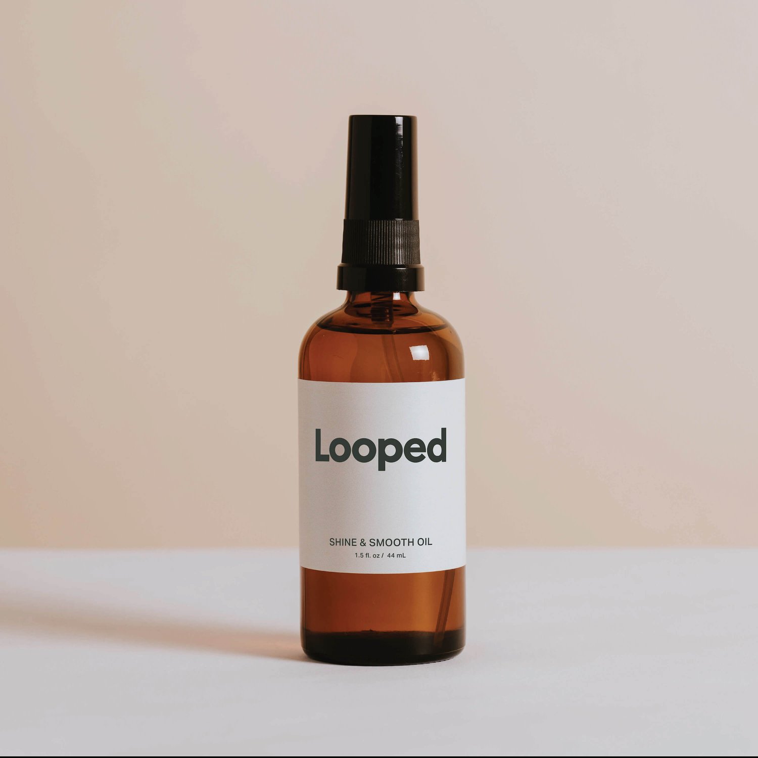 An image of a bottle of Looped Shine & Smooth Oil.