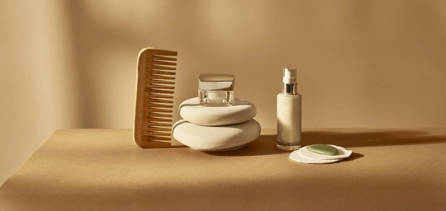 Neutral-toned home and self-care items arranged in warm light
