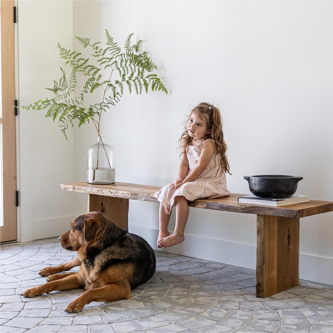 Teak bench styled in a quiet-luxury entryway with little girl and dog.jpg