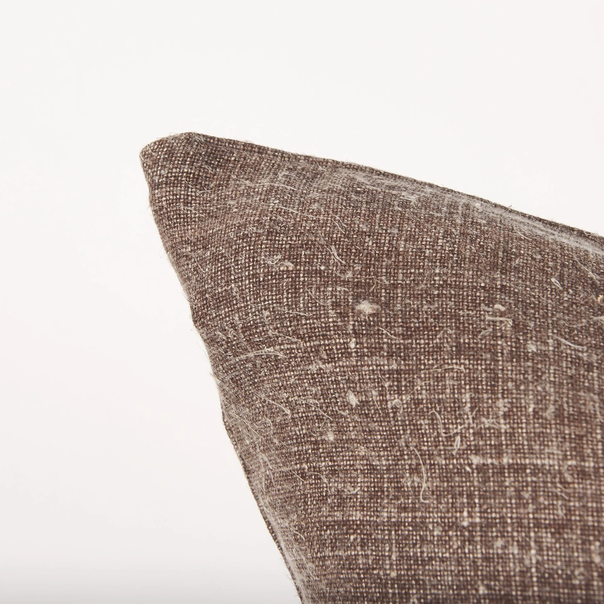 Corner close-up of brown textured linen pillow cover. (Copy) (Copy)