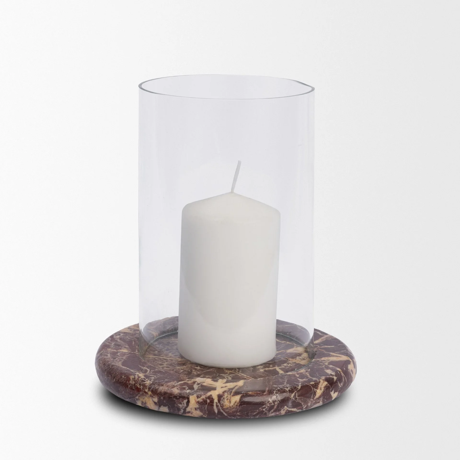 A glowing white pillar candle lit inside the red marble and glass hurricane holder.