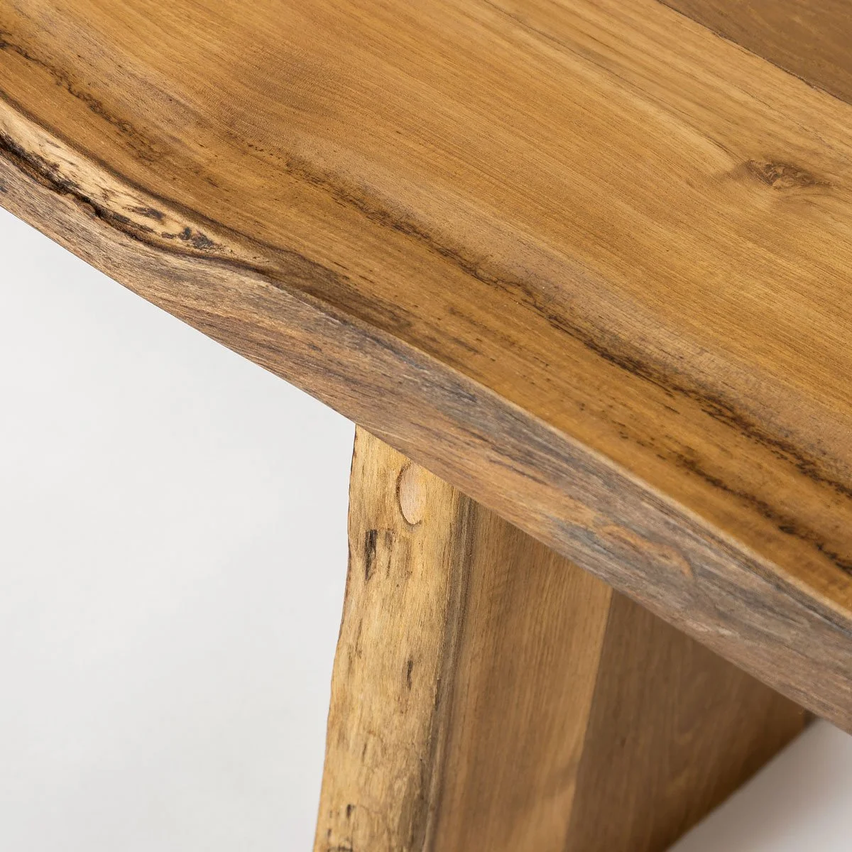 Detail view of handcrafted teak bench edges and natural contours.jpg