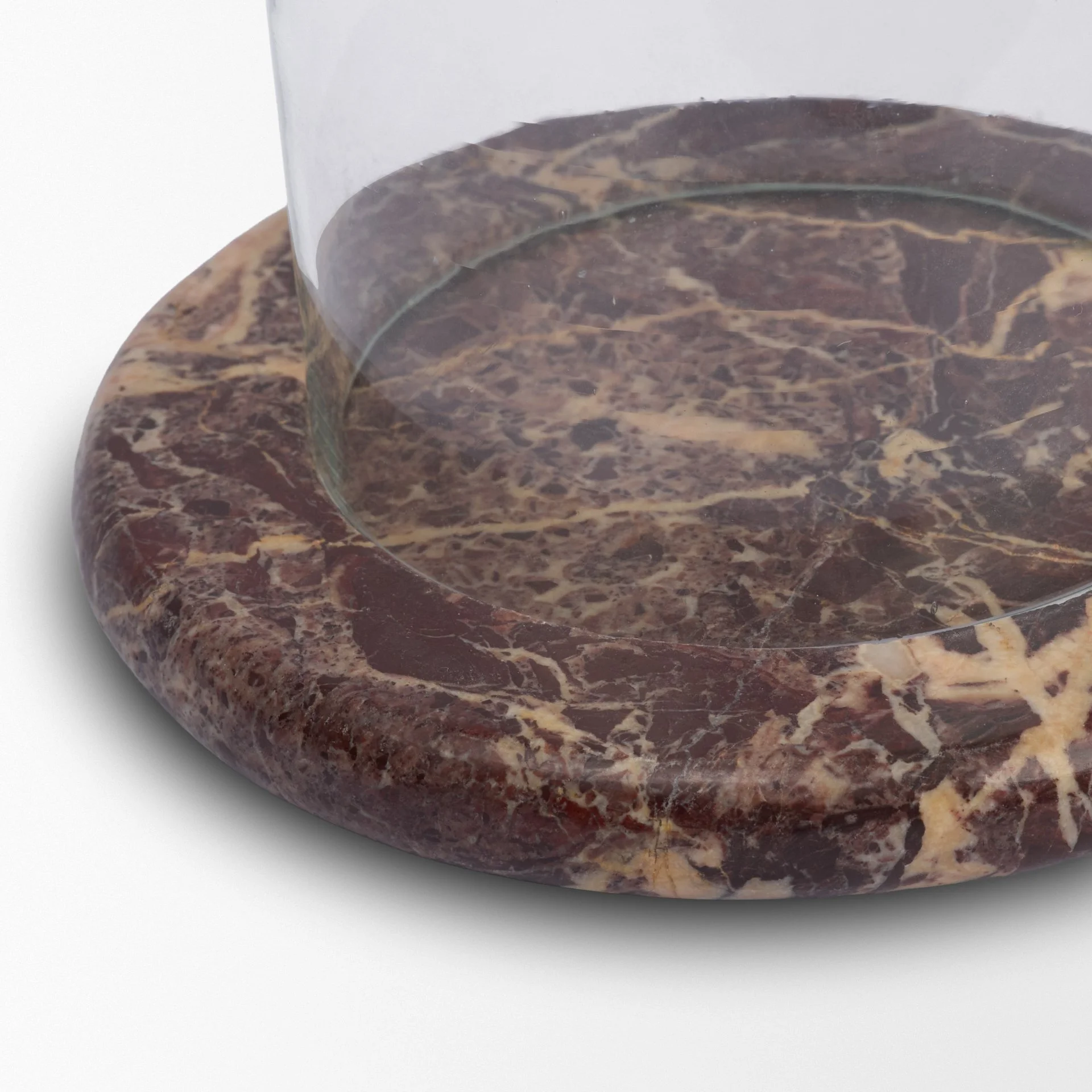 Close-up of the natural cream veining patterns on the bottom of the red marble base.