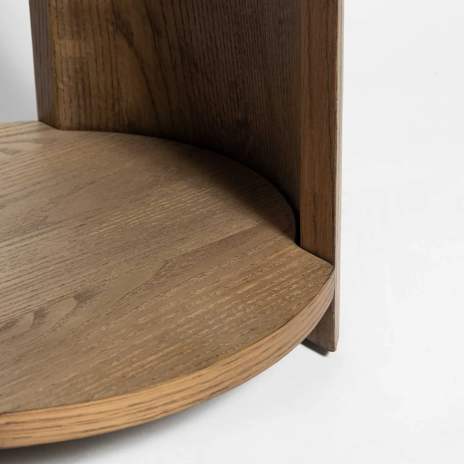 Underside angle showing curved C-shaped supports connecting top and base of modern oak table