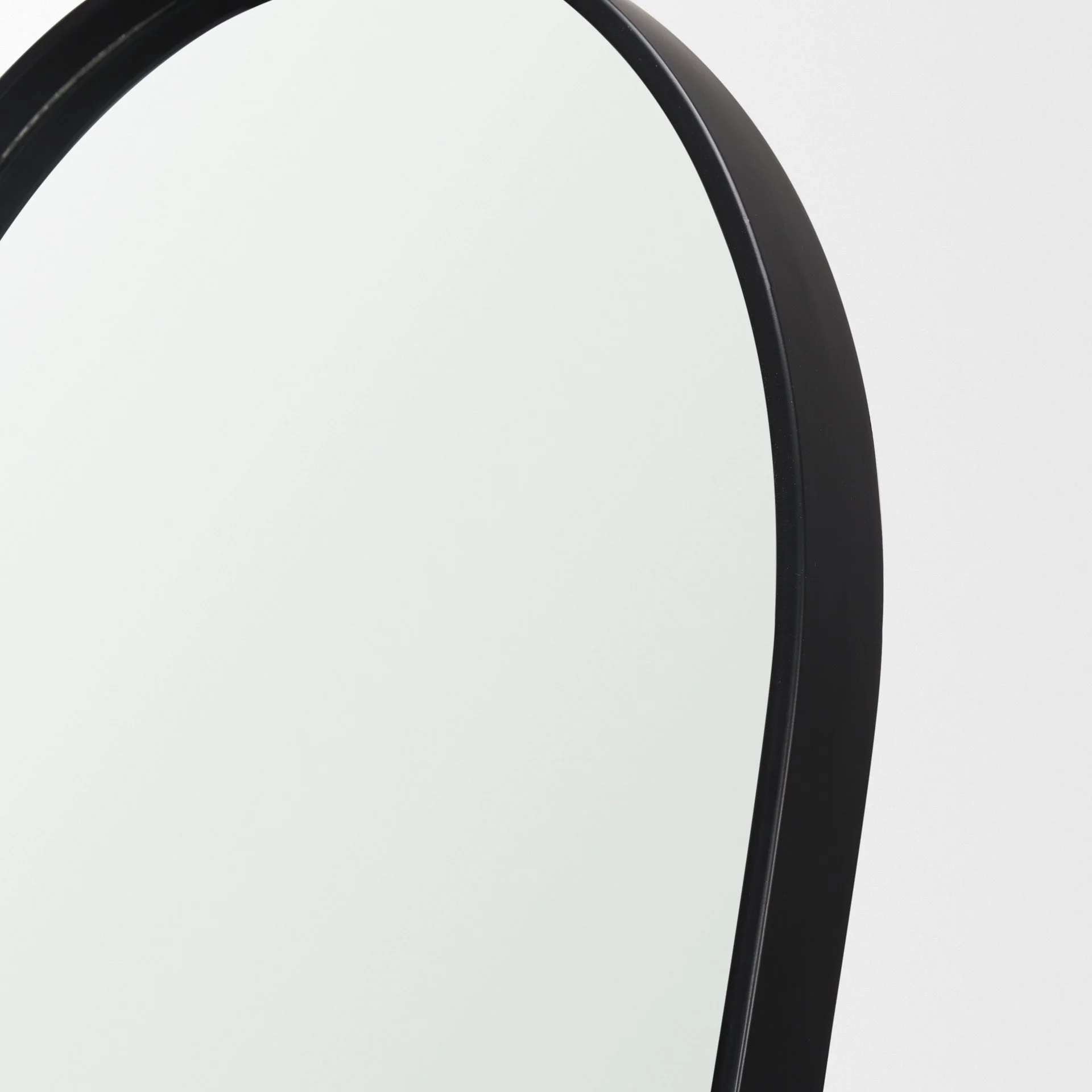 3. Angled view of oval floor mirror highlighting curved silhouette