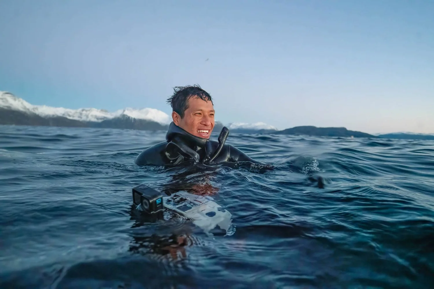 Smiling snorkeler in a wetsuit in the Arctic water