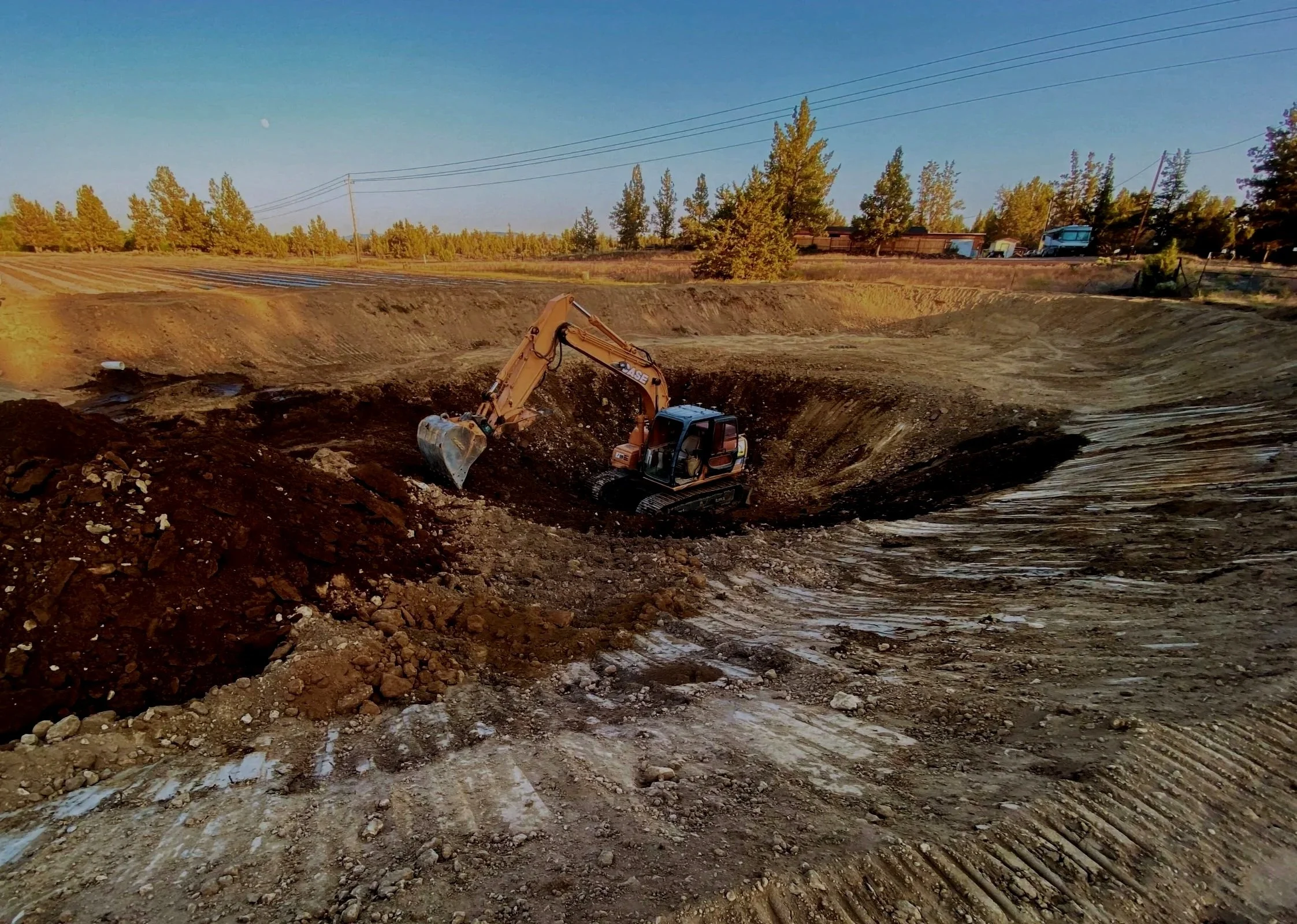 Excavator in a giant hole in a commercial excavation site in Central Oregon.