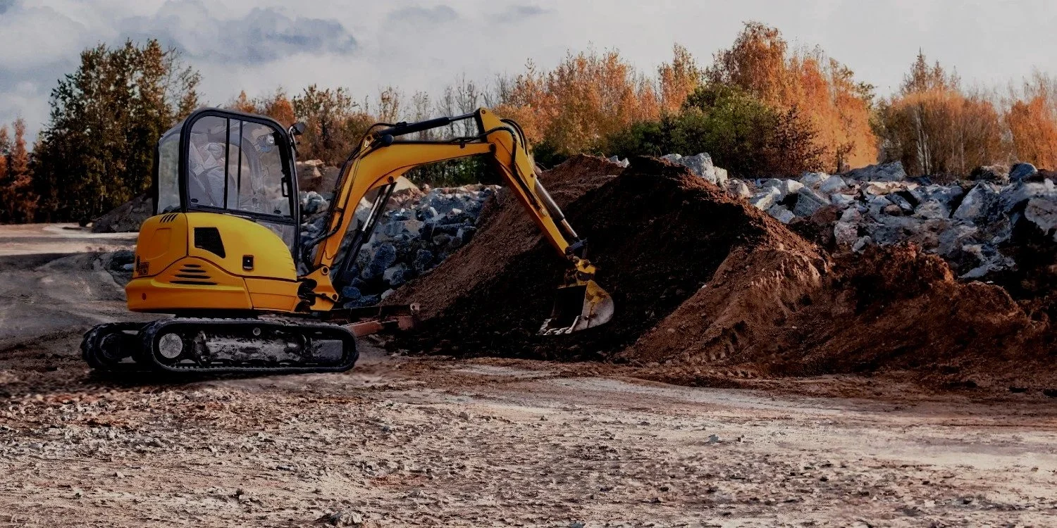 Small, yellow excavator in a Bend Oregon commercial excavation site.