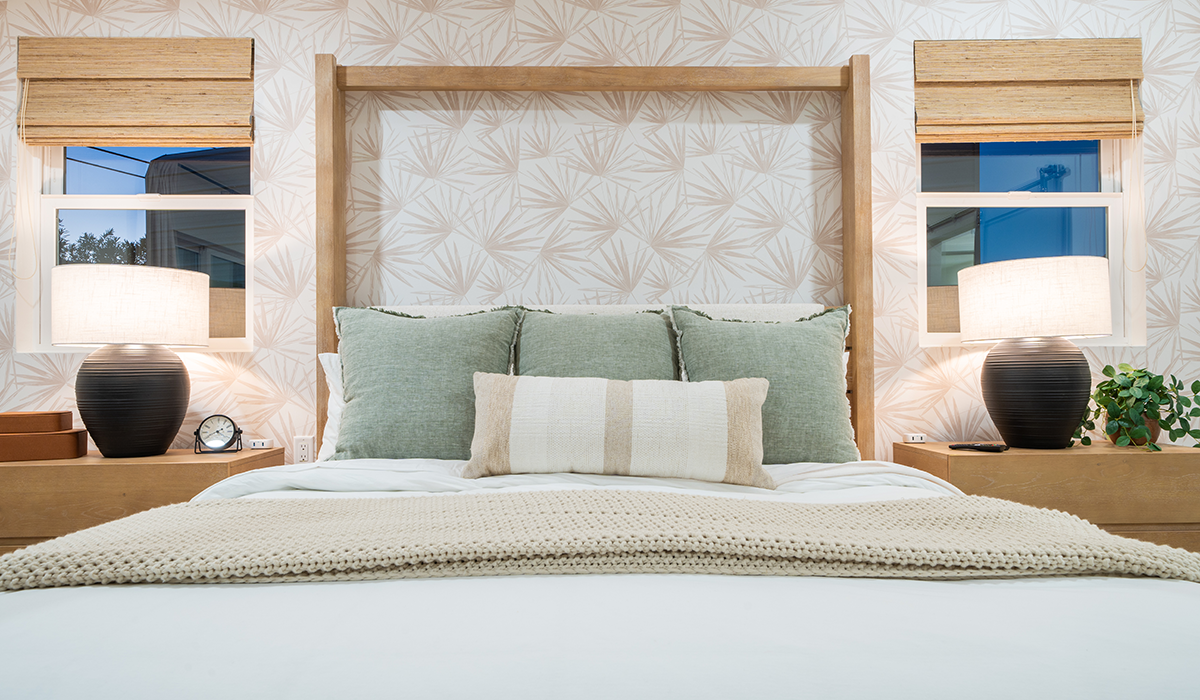 A beautifully styled bed and bedroom with soft hures and ceramic bedside lamps