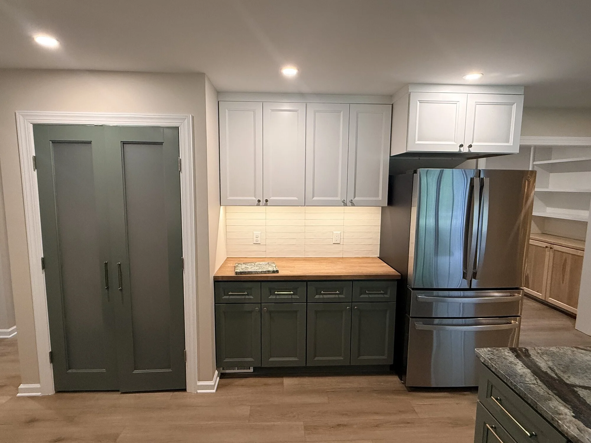 After — pantry doors, coffee bar, and under-cabinet lighting in the finished kitchen