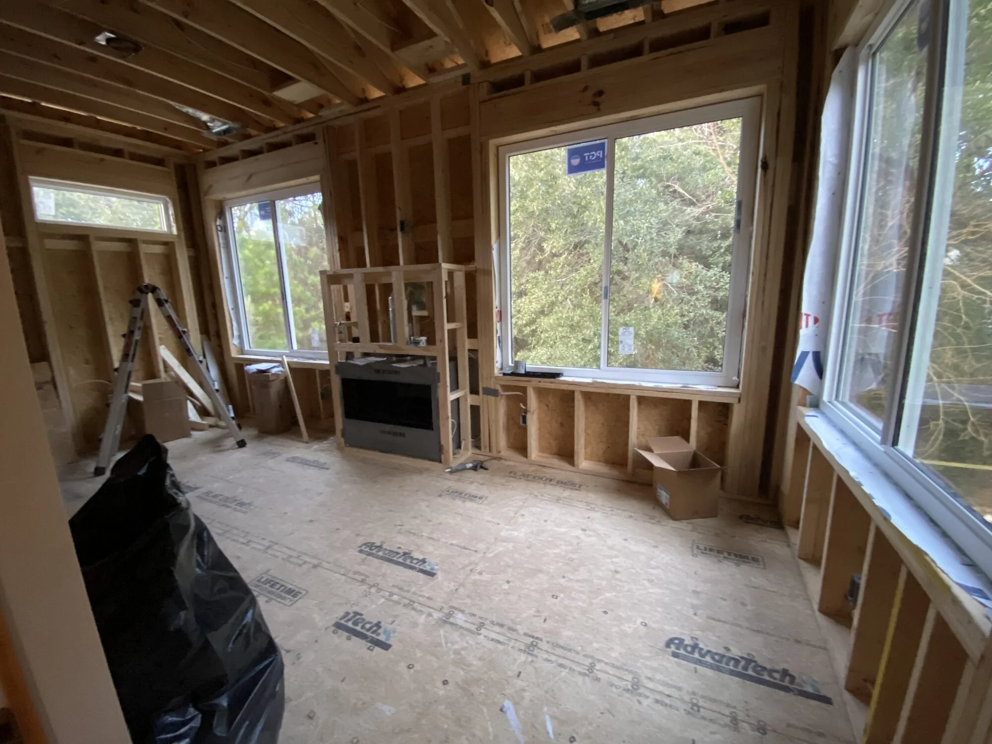 During — interior framing with the window wall and fireplace roughed in