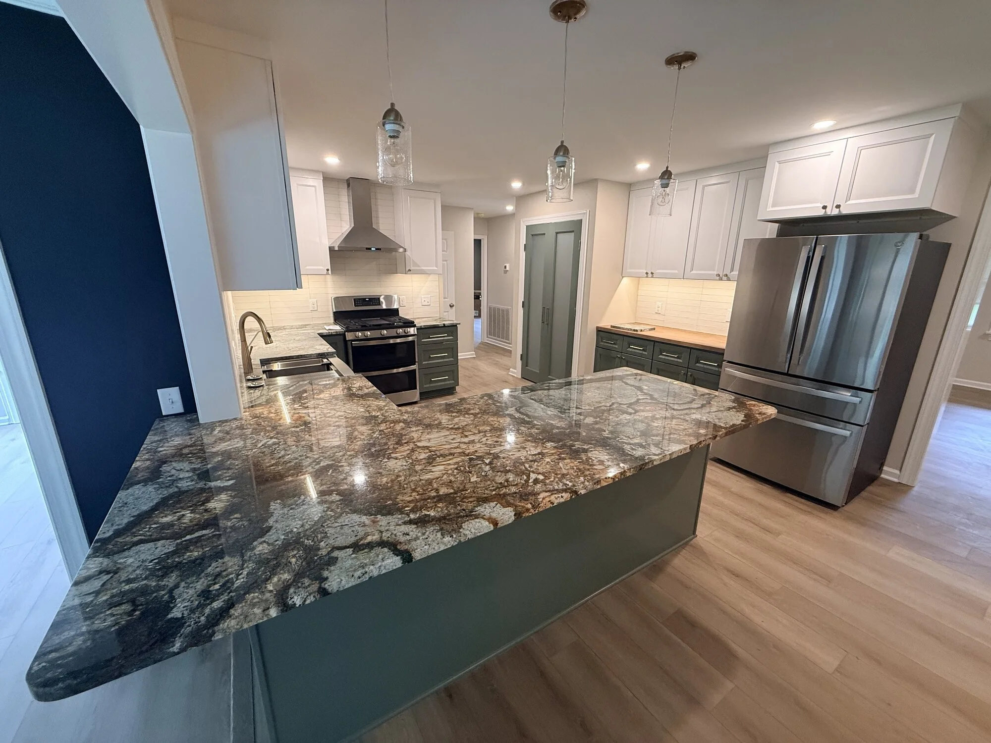 After — island with dramatic granite slab anchoring the new kitchen