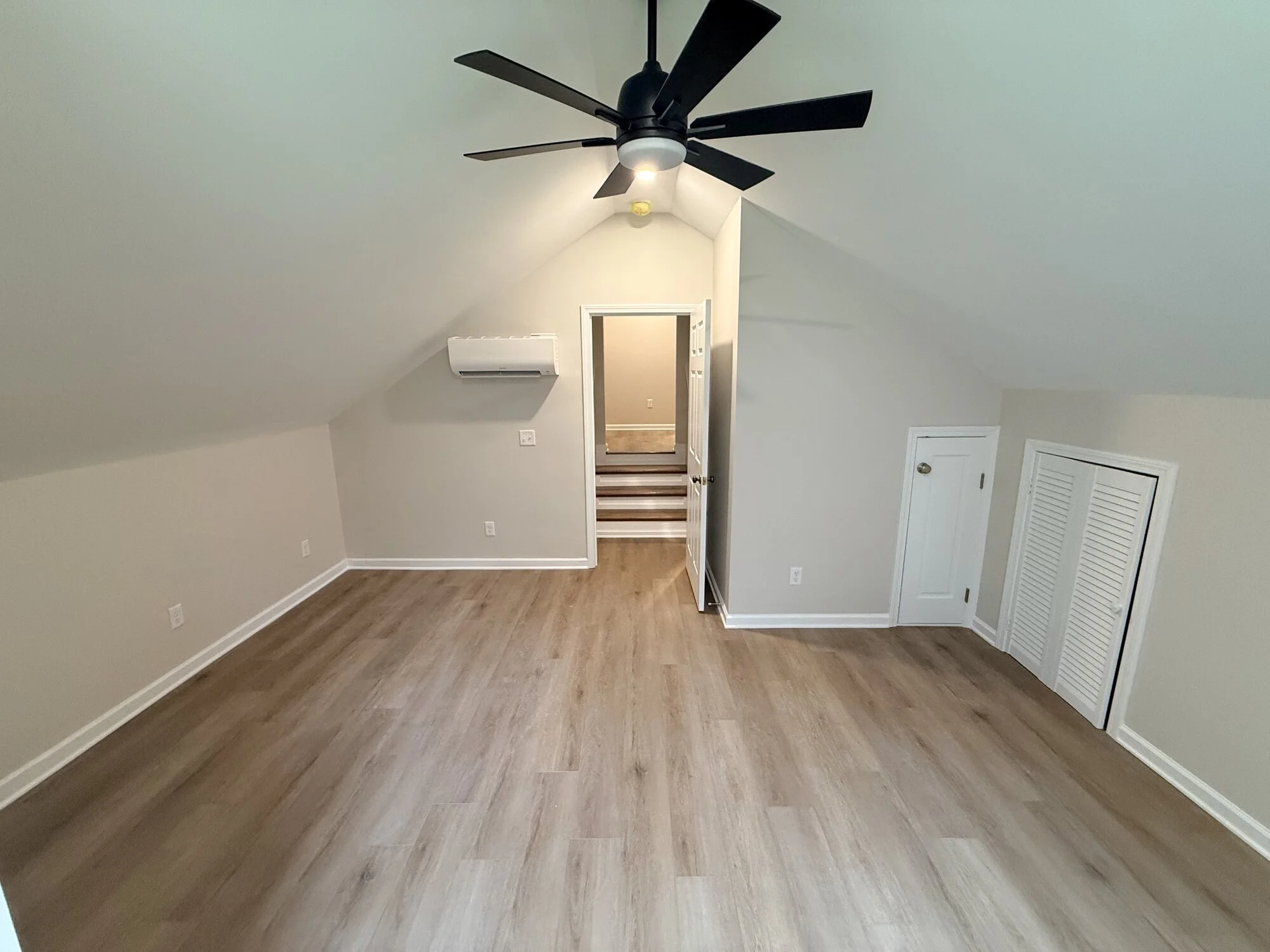 After — the finished bonus room, bright and open with new floors throughout and mini split for added comfort