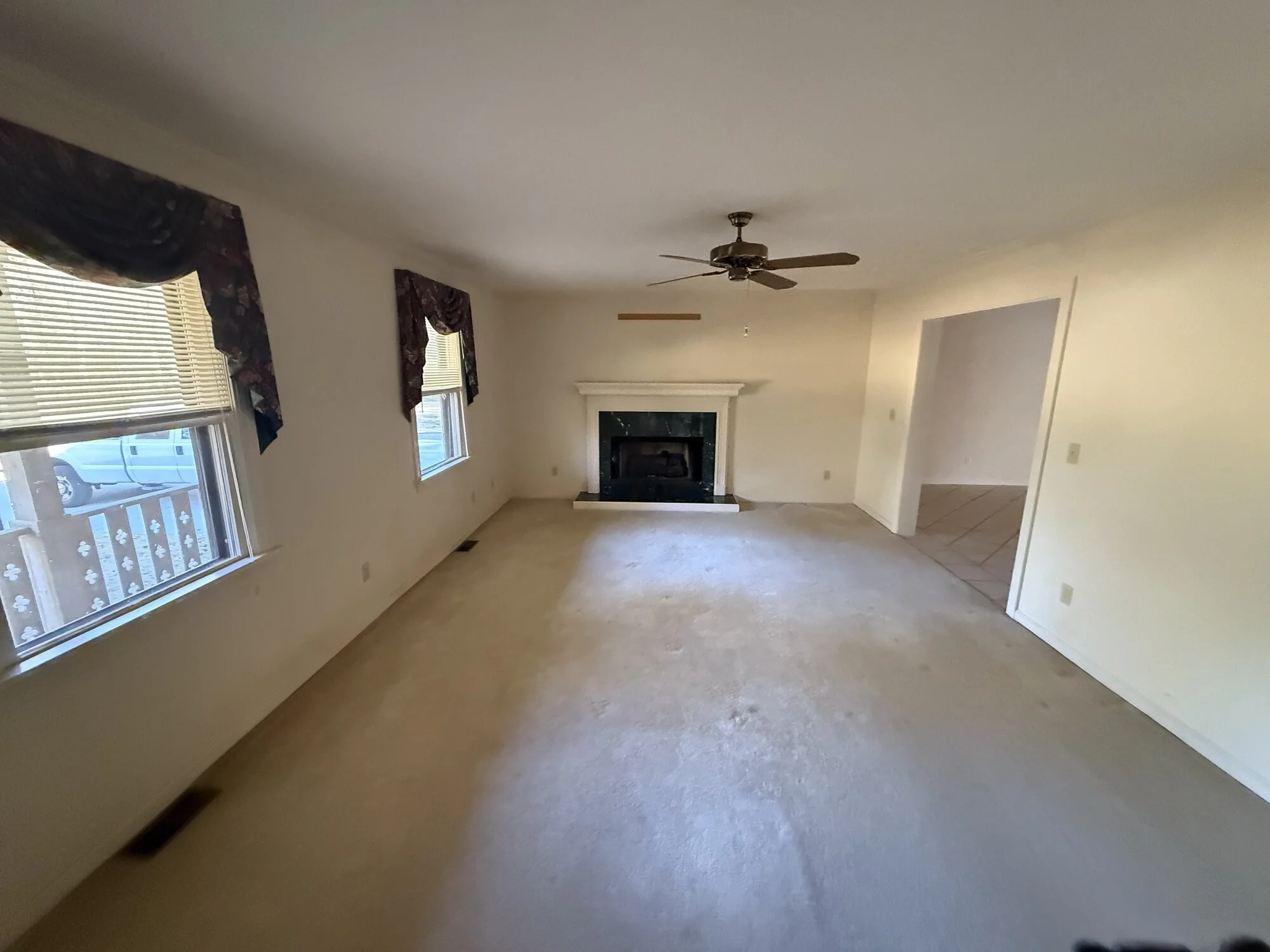 Before — living room with old carpet and dated brick fireplace wall
