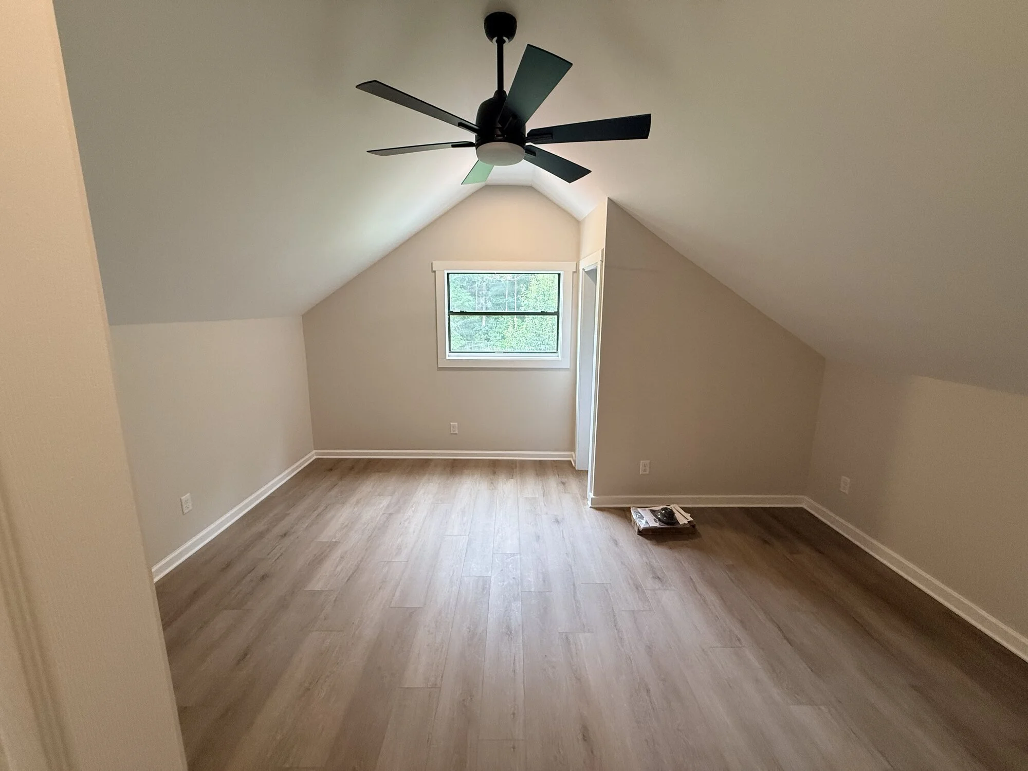 After — bonus room transformed with new flooring, smooth ceiling, and a modern ceiling fan